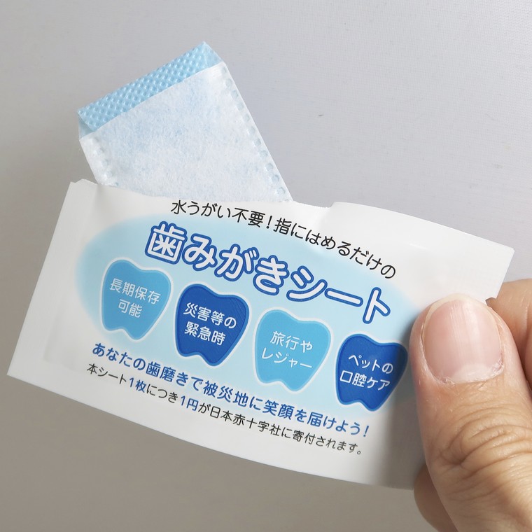 袋から歯みがきシートを取り出しているところ